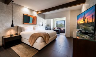 Mountain Casita King with flat screen television, nightstand, accent wall, comfortable couch and coffee table.
